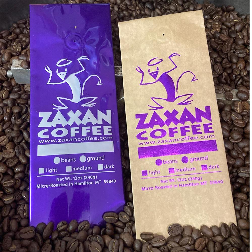 Two Zaxan Coffee bags on roasted coffee beans.