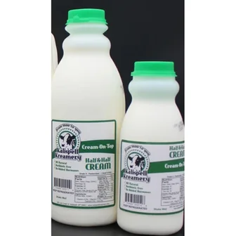 Two bottles of Kalispell Kreamery half-and-half with green caps.