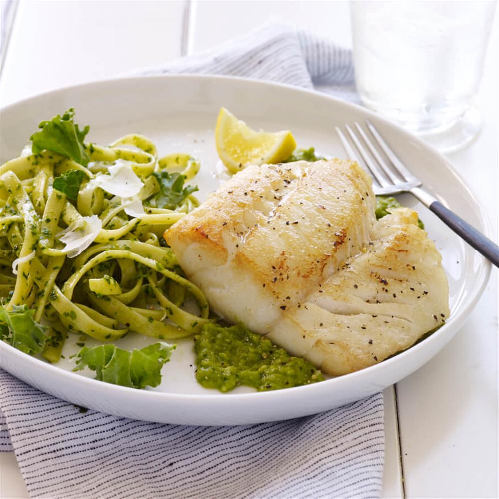 Cooked white fish with vegetables and lemon