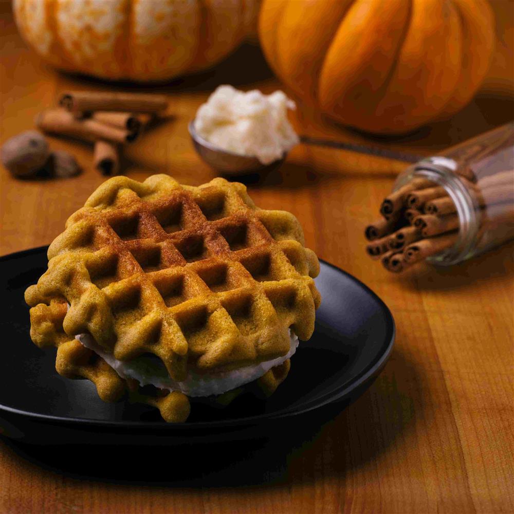 Waffle-style galette with cream and pumpkins nearby
