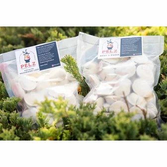 Two bags of Pelz pelmeni dumplings resting outdoors.