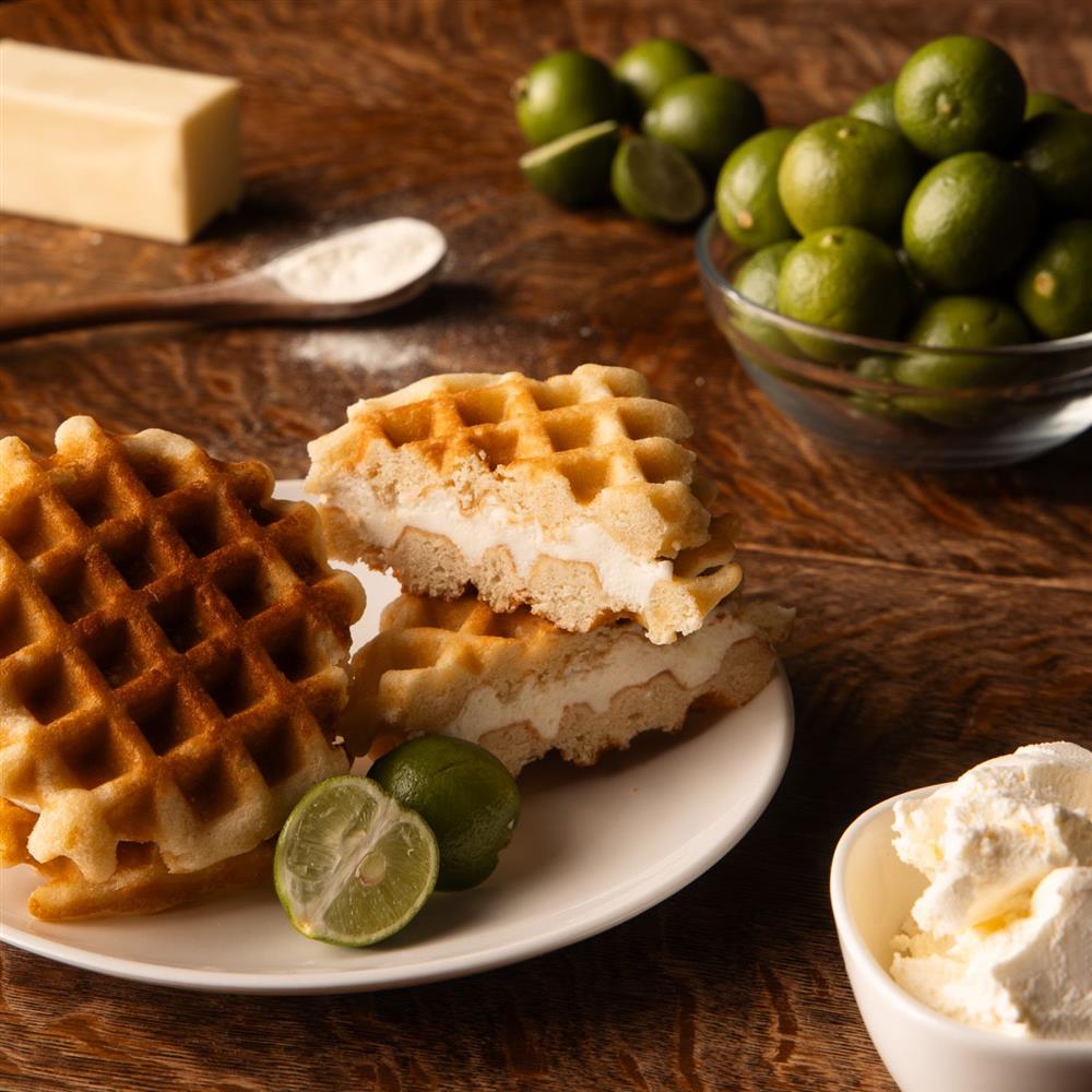 Waffle-style galette with cream and limes nearby