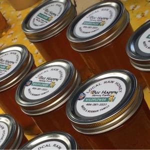 Bee Happy honey jars with labeled metal lids.