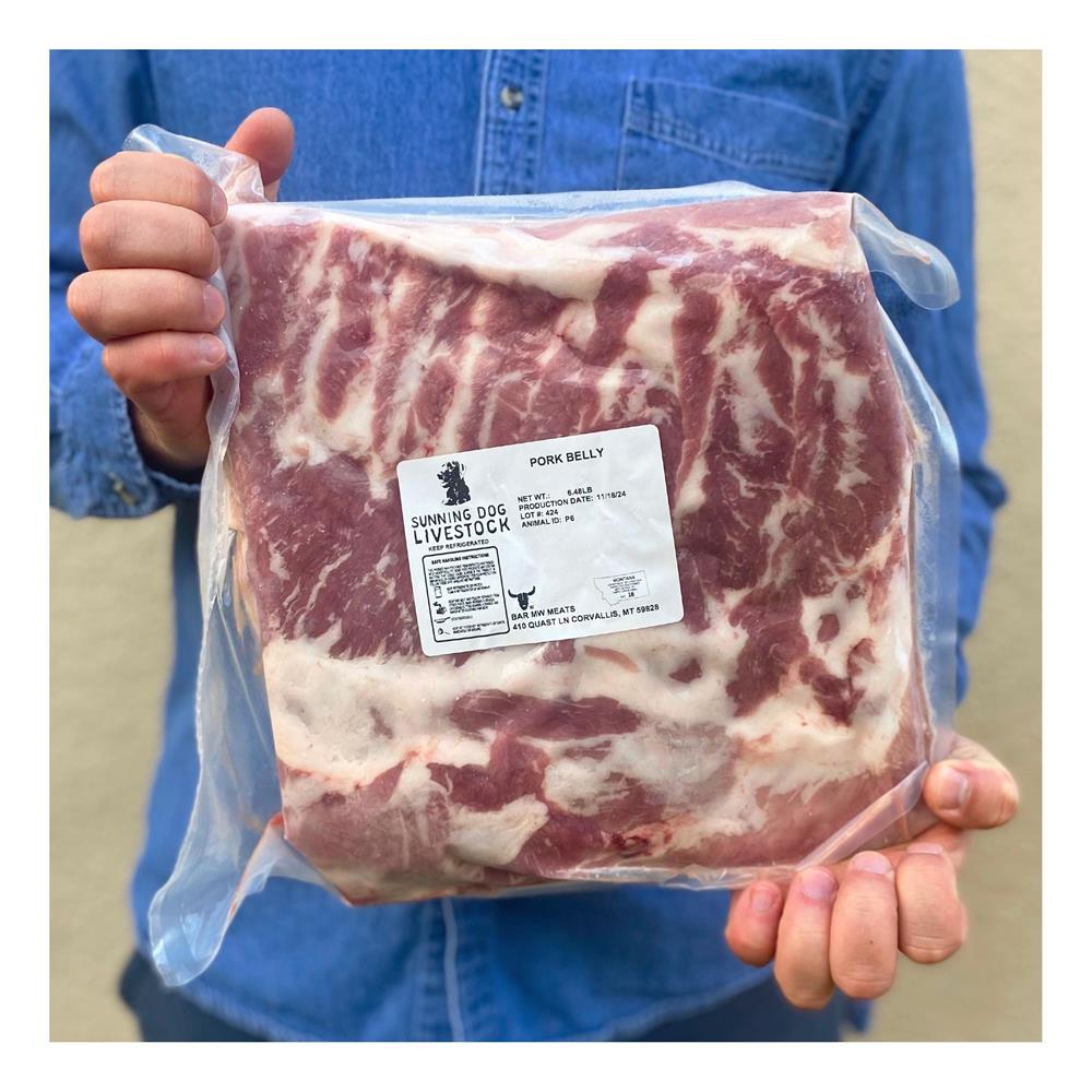 A person holding a labeled package of pork belly.