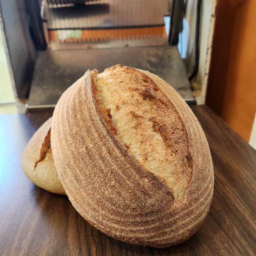 A round hearth bread loaf with a deeply scored crust.