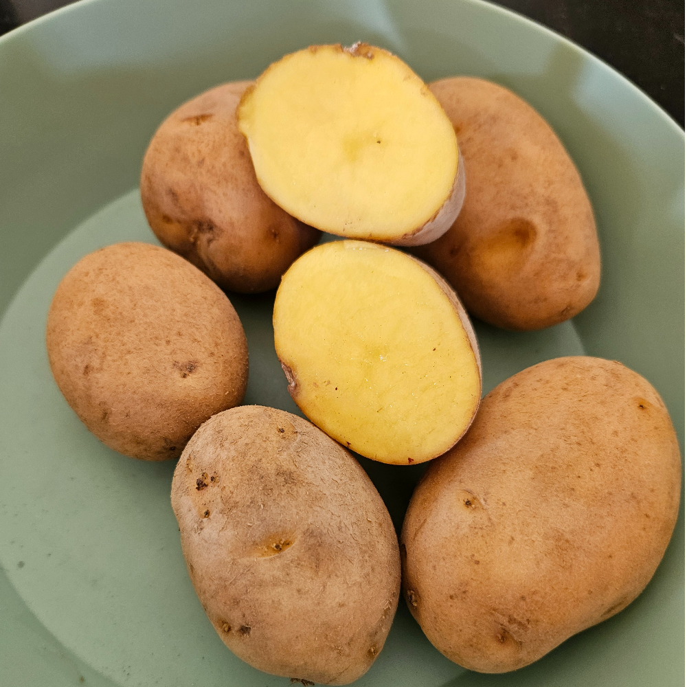 Whole and halved yellow potatoes