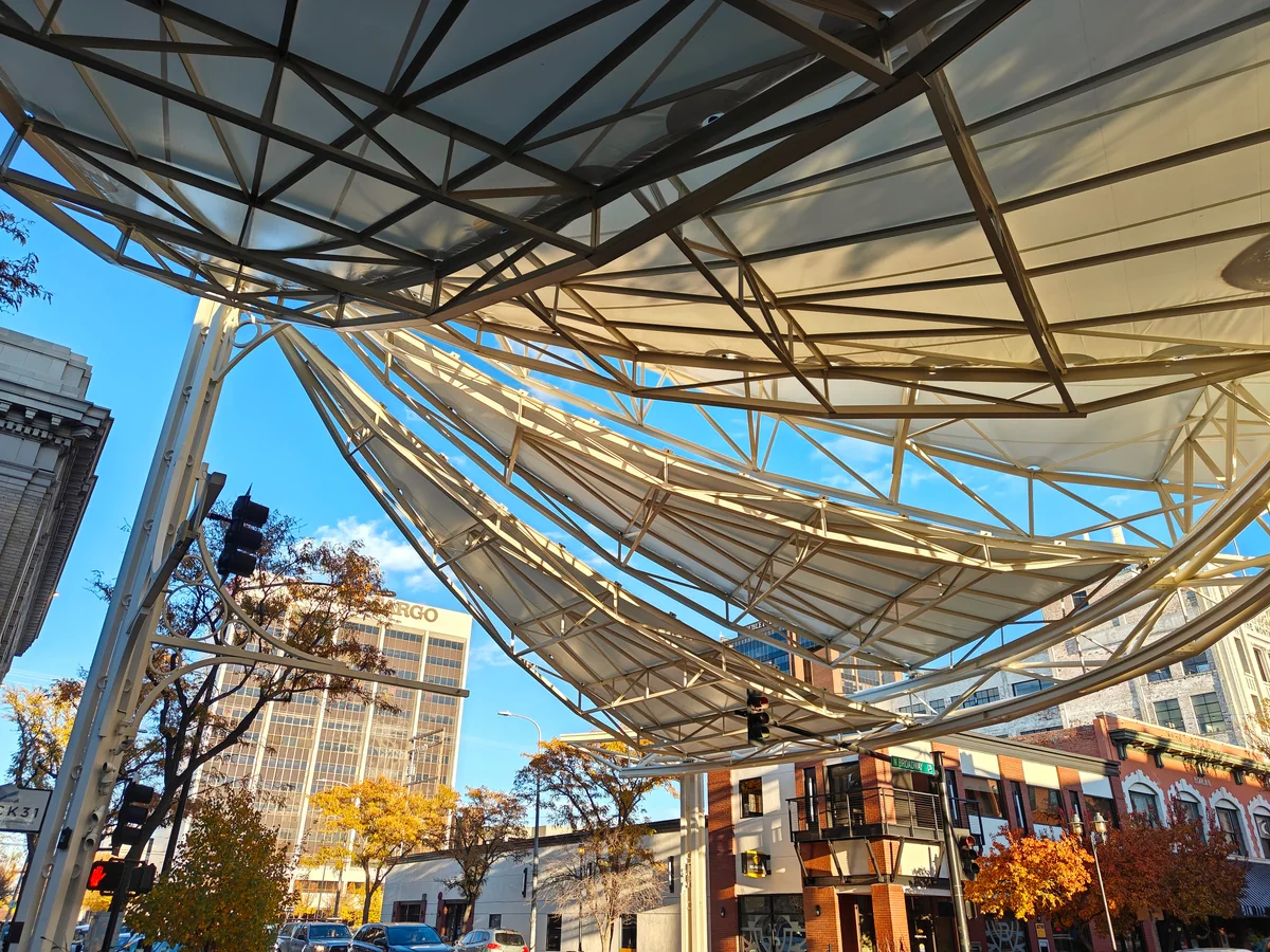 The Skypoint canopy above North Broadway and Second Avenue North in downtown Billings, with autumn trees below.